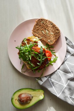 Yumurta ve pastırma bir plaka ile ekmek üzerine avokado