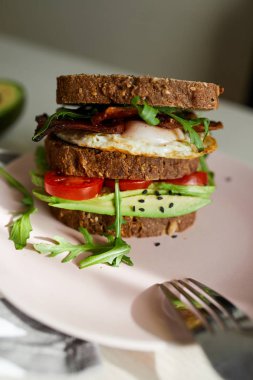Yumurta ve pastırma bir plaka ile ekmek üzerine avokado