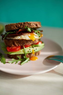 Yumurta ve pastırma bir plaka ile ekmek üzerine avokado