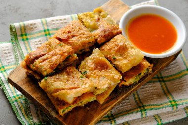 Martabak Telor veya Martabak Telur. Yumurta, et ve baharatla doldurulmuş tuzlu tavada kızartılmış hamur işi. Martabak Telur Endonezya sokak yemeklerinden biridir.