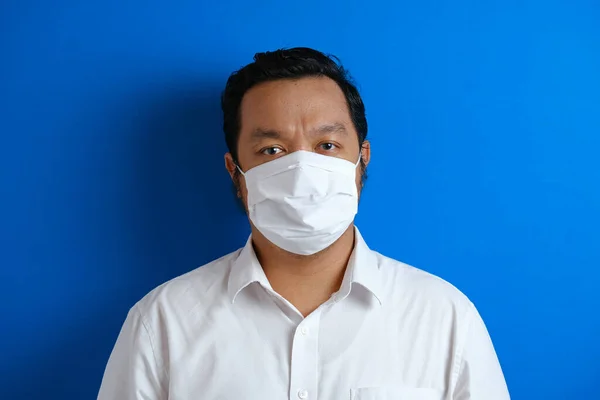 a fat Asian man wearing a mask to prevent transmission of the corona virus