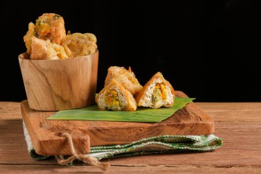 Tahu Susur, içindekileri gösteren parçalarla bir kesme tahtasının üzerinde servis ediliyor. Endonezya 'dan geleneksel bir yiyecek. Un hamuruna sarılmış kızarmış sebzelerle doldurulmuş soya peynirinden yapılıyor.