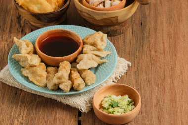 Pempek kırsal ahşap masada servis edilir. Pempek, Endonezya 'nın geleneksel gıdasıdır. Balık ve tapyokadan yapılma, tatlı ve özel ekşi sos ya da cuka adı verilen sirke sosuyla servis edilir.