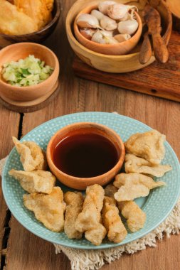 Pempek kırsal ahşap masada servis edilir. Pempek, Endonezya 'nın geleneksel gıdasıdır. Balık ve tapyokadan yapılma, tatlı ve özel ekşi sos ya da cuka adı verilen sirke sosuyla servis edilir.