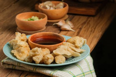 Pempek kırsal ahşap masada servis edilir. Pempek, Endonezya 'nın geleneksel gıdasıdır. Balık ve tapyokadan yapılma, tatlı ve özel ekşi sos ya da cuka adı verilen sirke sosuyla servis edilir.