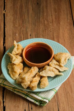 Pempek kırsal ahşap masada servis edilir. Pempek, Endonezya 'nın geleneksel gıdasıdır. Balık ve tapyokadan yapılma, tatlı ve özel ekşi sos ya da cuka adı verilen sirke sosuyla servis edilir.