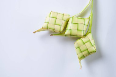 Ketupat 'ın üst görüntüsü beyaz arkaplanda izole edildi. Tabaklanmış hindistan cevizi yapraklarından yapılmış pirinç ambalajından yapılan tipik bir yemek..