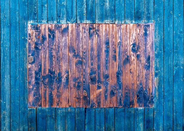 Parede da casa de tábuas de madeira azuis com uma janela de embarque. textura de uma árvore velha. fundo de madeira azul — Fotografia de Stock