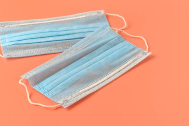 Virüse karşı korunmak için antiviral tıbbi maske. Coronavirus covid-19 salgınına karşı koruma. Pembe arka planda cerrahi mavi maske. Virüs koruması ve kendini izole etme