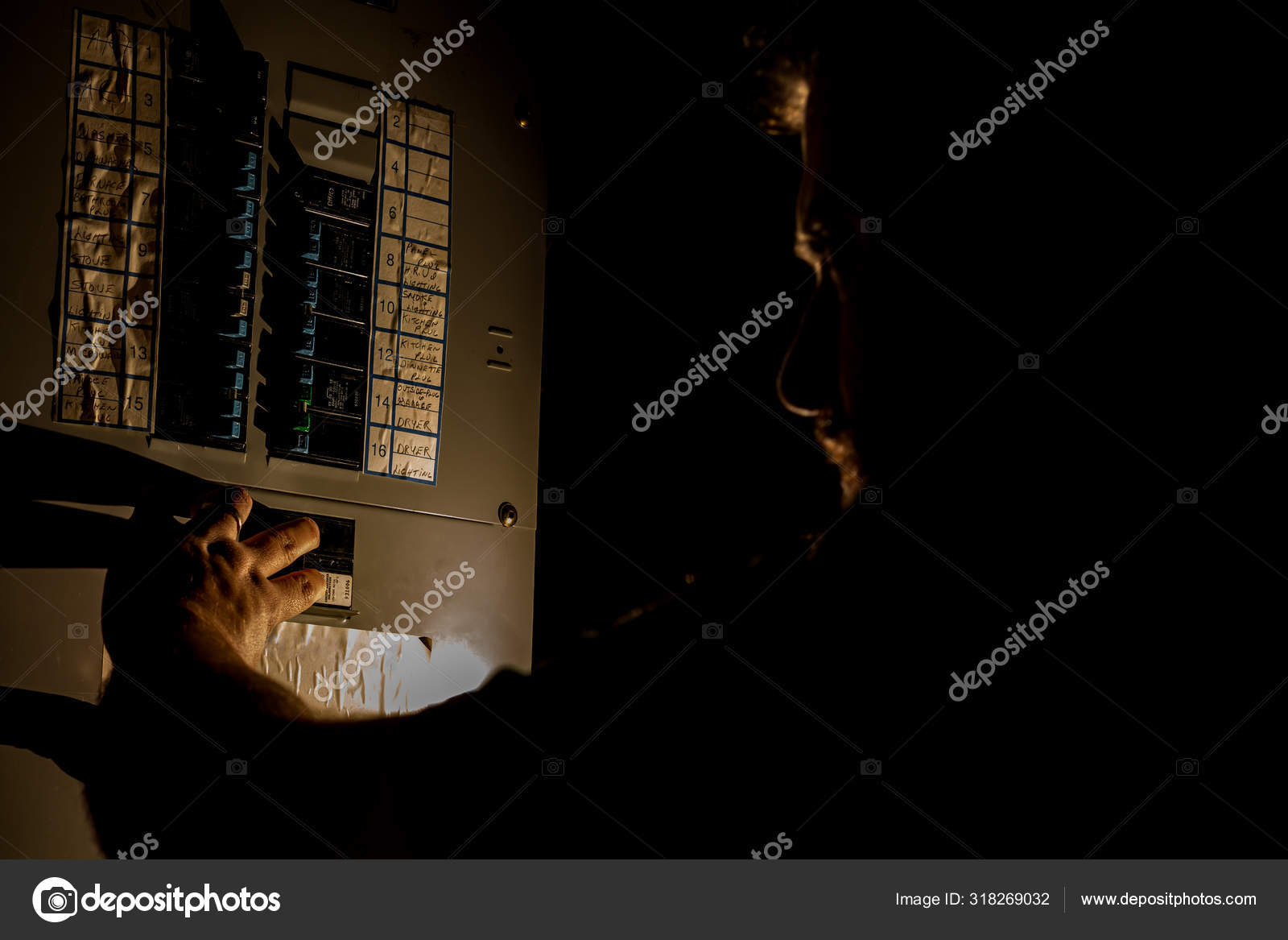 Man Checks Home Fuse Box in a Dark Power Outage Stock Photo by