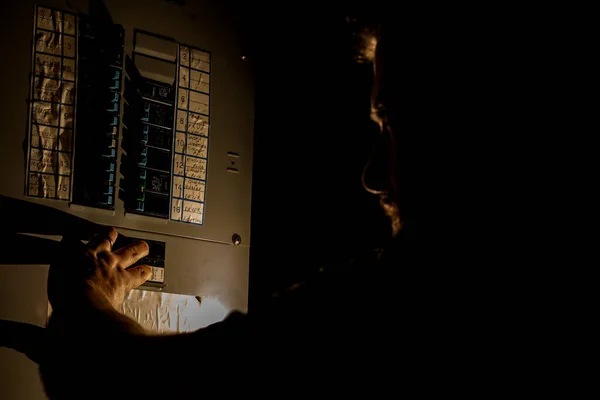 Man Checks Home Fuse Box in a Dark Power Outage — Stock Photo, Image