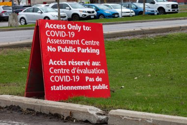 OTTAWA, ONTARIO, CANADA - 1 Mayıs 2020: Brewer Park 'taki bir tabela, park yerinin Ottawa Halk Sağlığı (OPH) tarafından işletilen COVID-19 değerlendirme merkezi için olduğunu gösteriyor).