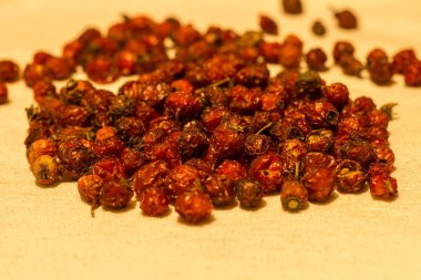 Kurumuş gül üzümleri masadaki doğal tuval masa örtüsünün üzerinde..