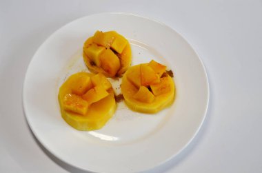 Vejetaryen Diyet Yemekleri. Beyaz bir tabakta bal ve tarçınlı fırında balkabağı dilimleri var..