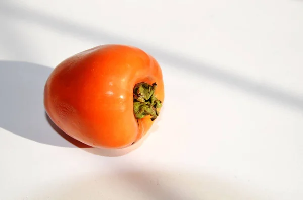 Vegetarian Diet Food. On a white background fruit vitamin ripe sweet persimmon.