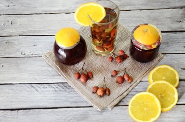 Dokular ve arka planlar. Beyaz boyanmış eski ahşap tahtaların arka planında kurumuş gül kalçası dalları ve taze portakal dilimleri var..