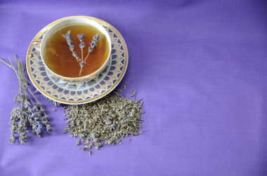 Lavanta Kraliçesi Aromaterapisi. Mor arka planda mis kokulu lavanta çayı, filiz ve kurutulmuş lavanta var..