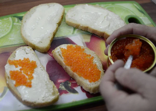 朝の朝食テーブルの上には サーモンの粒状のキャビア サンドイッチ バターと赤キャビアでバターを塗りました — ストック写真