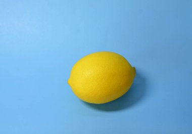 Backgrounds and textures. On a blue background lies a yellow appetizing citrus lemon.