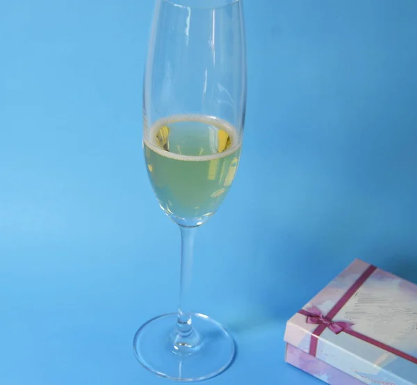 Очки Шампанским Стоят Синем Фоне Желтый Лимон Лежит — стоковое фото