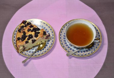 Homemade baking. On the table is a dish with a freshly baked delicious blackcurrant pie, a cup of tea.