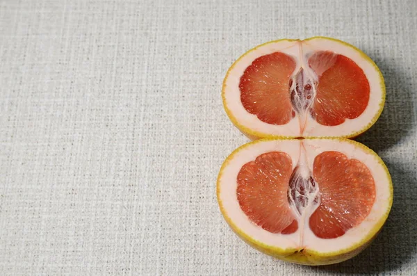 Vitamin, vegetarian food. On a white background is a tropical grapefruit sliced with mouth-watering juicy sweets with light bitter red slices.