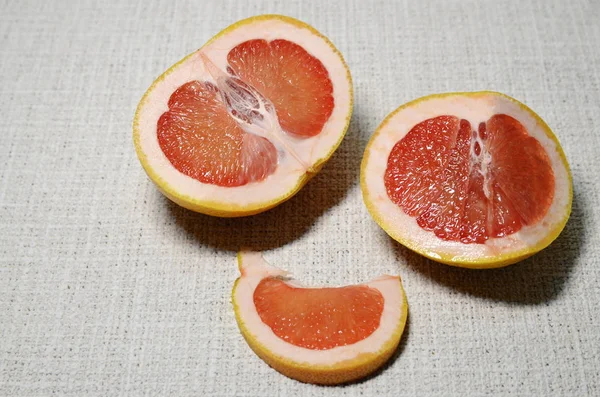 Vitamin, vegetarian food. On a white background is a tropical grapefruit sliced with mouth-watering juicy sweets with light bitter red slices.