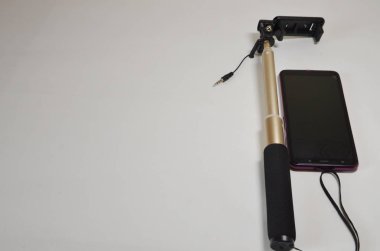 A set for a blogger. On a white background smartphone and selfie stick for photo and video.