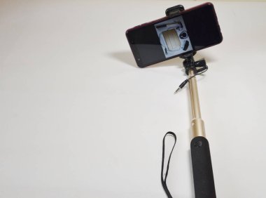 A set for a blogger. On a white background smartphone and selfie stick for photo and video.