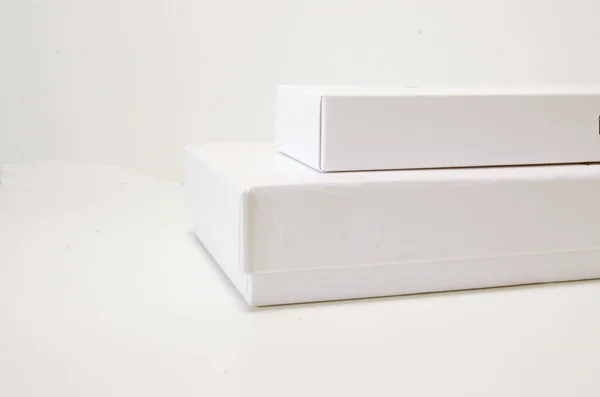 On a white background two white packaging boxes of different sizes.