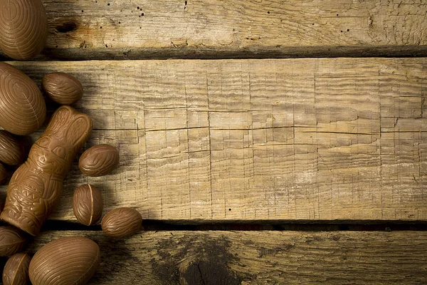 Çikolatalı paskalya tavşanı ve tahta arka planda yumurtalar. Üst görünüm.