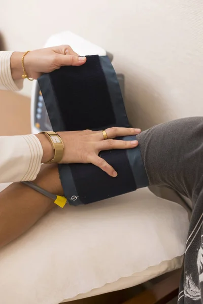 护士包装血压表工具的病人手臂 — 图库照片