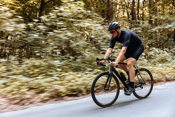 Sportowy Brodaty Mężczyzna Okularach Czarny Kask Rowerze Wśród Zielonego Lasu — Zdjęcie stockowe