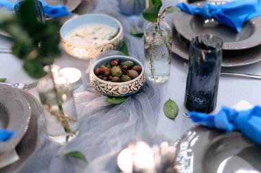 Süslü masayı tekstil, vazo ve mumlarla kapatın. Ziyafet için lezzetli yemekler. Yemek hizmeti ve etkinlik için özel eleman alma kavramı 