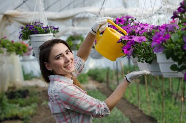 Neşeli kız çiçekler sera sulama