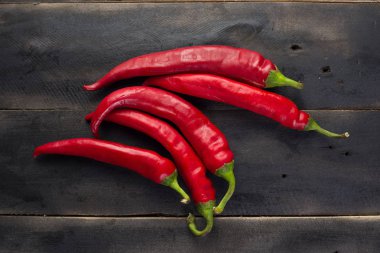 Siyah ahşap tahta üzerinde kırmızı biber biber