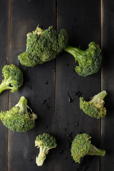 Broccoli på svart trä bakgrund — Stockfoto