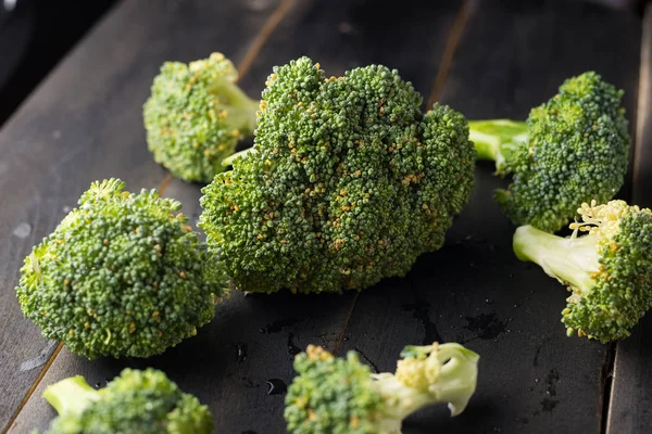 Broccoli บนพื้นหลังไม้สีดํา — ภาพถ่ายสต็อก