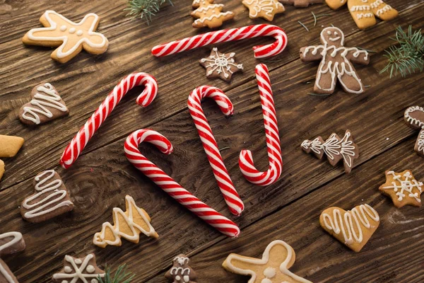 Weihnachtsplätzchen, Zuckerstangen auf hölzernem Hintergrund. Urlaubsstimmung. Ansicht von oben. — Stockfoto