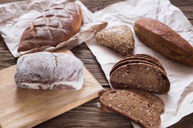 Tablo yakın çekim farklı ekmek. ahşap arka plan, Kraft kağıt üzerinde sağlıklı ekmek.