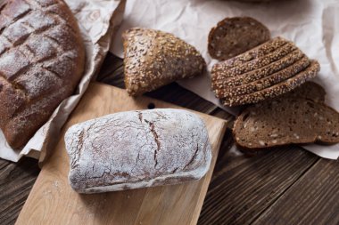 Tablo yakın çekim farklı ekmek. ahşap arka plan, Kraft kağıt üzerinde sağlıklı ekmek.