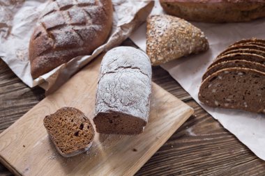 Tablo yakın çekim farklı ekmek. ahşap arka plan, Kraft kağıt üzerinde sağlıklı ekmek.