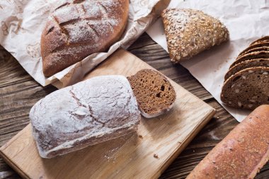 Tablo yakın çekim farklı ekmek. ahşap arka plan, Kraft kağıt üzerinde sağlıklı ekmek.