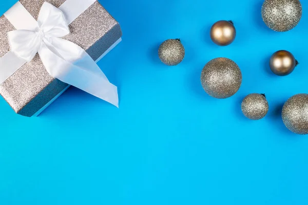 Vánoční koule s dárkem na modrém pozadí — Stock fotografie