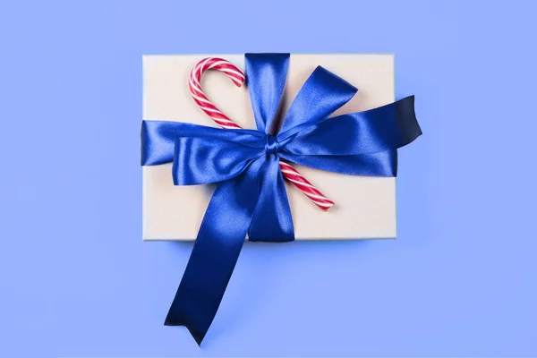 Box na řemesla s módní modrou mašlí a červenými vánočními cukrovinkami — Stock fotografie