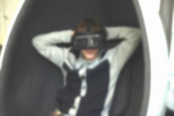 Мальчик в кресле сидит в очках виртуальной реальности — стоковое фото