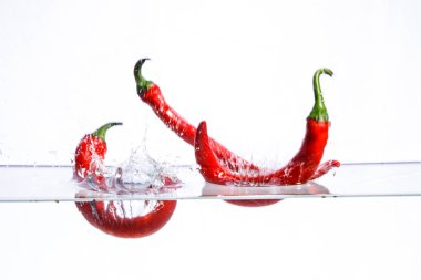 Suda sıcak kırmızı biber, içinde su ve meyve yüzüyor..