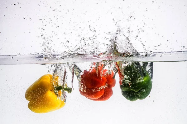 Stock image three peppers falling in water