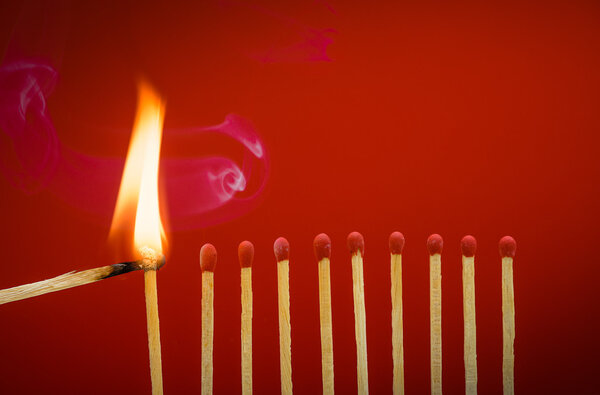 Burning matchsticks setting fire to its neighbors