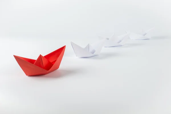 Κόκκινο χαρτί πλοίο οδηγεί ανάμεσα σε λευκό — Φωτογραφία Αρχείου